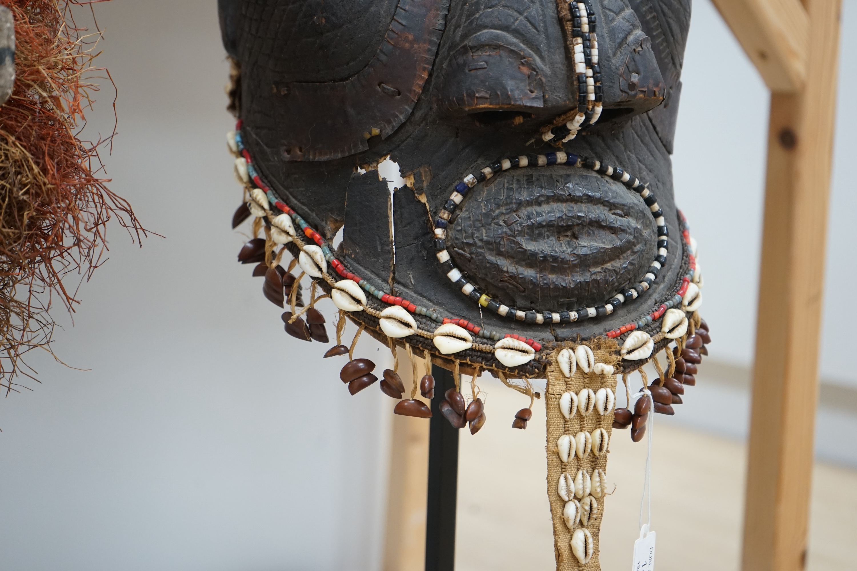 An African Kuba helmet mask and another horned mask, both on stands & one spare. Condition - helmet mask damaged